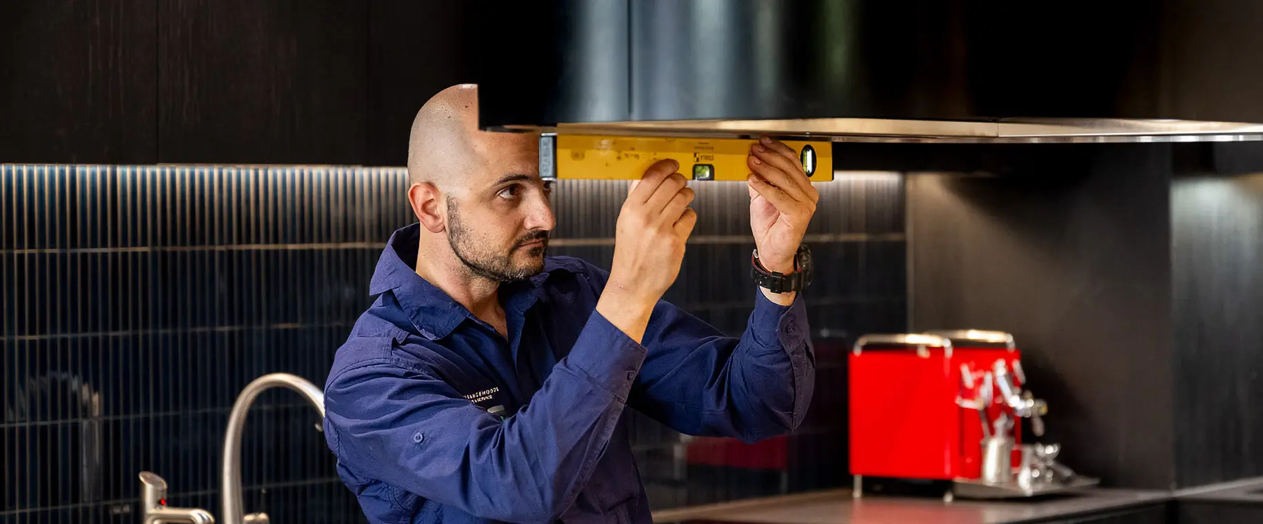 Peter from Sydney Rangehoods installing a new rangehood in a kitchen