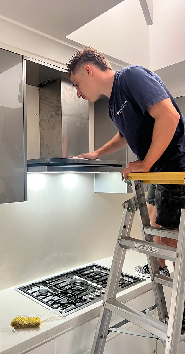A rangehood being installed by one of our electricians