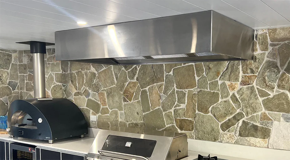 A large stainless steel rangehood in an outdoor area